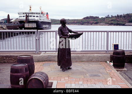 Statue on the dock wall of Stornoway with ferry in background Stock Photo