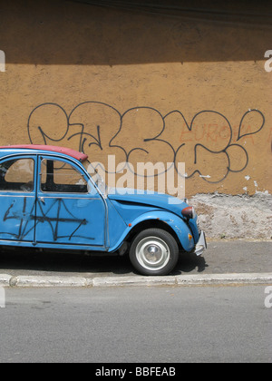 one citroen 2cv covered with graffiti in street in city town Stock Photo