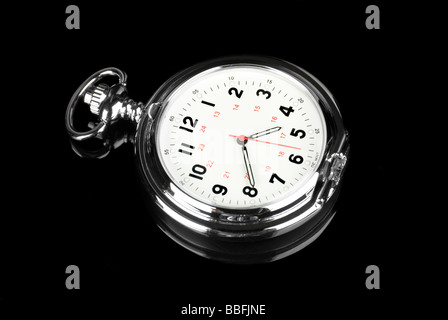 A pocket watch on a reflective black background shows it elegance and style Stock Photo