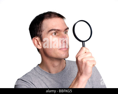 Man looking through magnifying glass Stock Photo