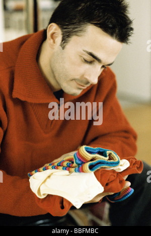 Man looking at baby clothes, close-up Stock Photo