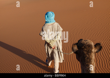 Africa, North Africa, Morocco, Sahara Desert, Merzouga, Erg Chebbi, Berber Tribesman Leading Camel Stock Photo