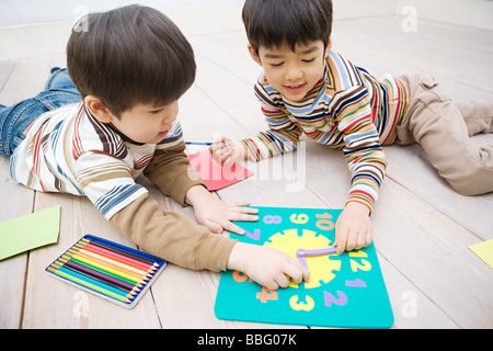 Boys playing with a clock Stock Photo