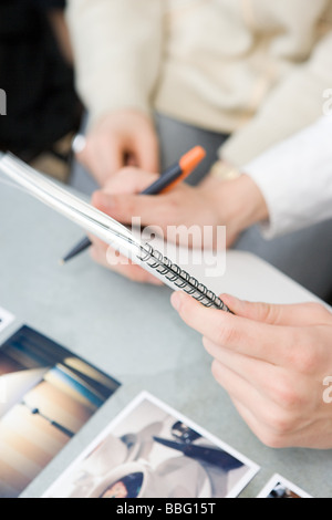 People with notepad and photographs Stock Photo