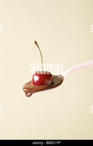 Cherry and melted chocolate on spoon Stock Photo