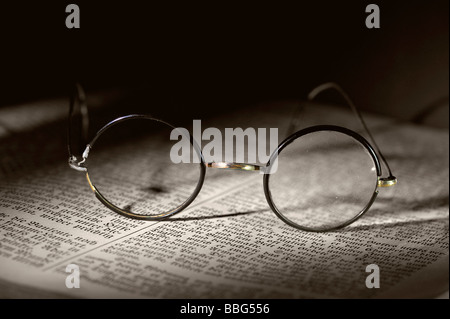 Old reading glasses on old book Stock Photo