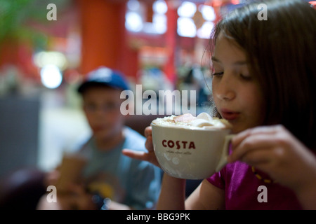 White girl Drinking coffee in China court Costa Ibn Battuata Dubai Stock Photo