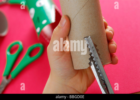 Children's hands cutting with zigzag scissors Stock Photo