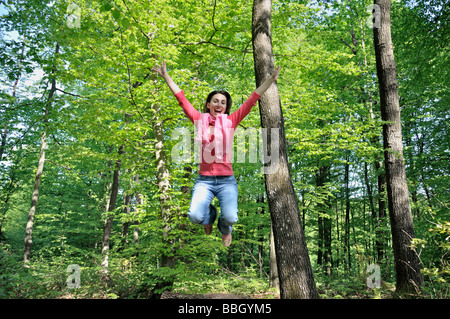 Young woman jumping in air laughing low angle view Stock Photo