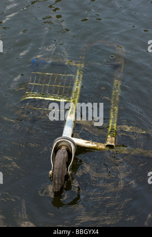 A supermarket shopping trolley dumped in the canal Stock Photo