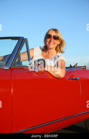 Young woman in red convertible car Stock Photo - Alamy