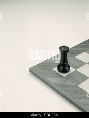 Black Castle chess piece on black and white chessboard. Stock Photo