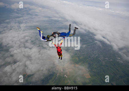 Freefly skydive team is training a special HYBRID formation over a spectacularly cloud scenery in the sky with 130 MpH. Stock Photo
