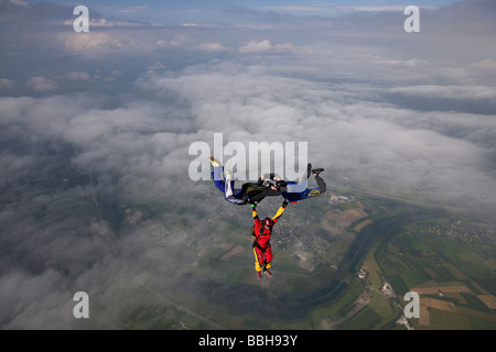 Freefly skydive team is training a special HYBRID formation over a spectacularly cloud scenery in the sky with 130 MpH. Stock Photo