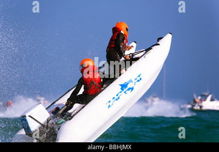 Two people in a ZapCat racing boat in action at sea off the Bournemouth coast. Dorset. UK. Stock Photo