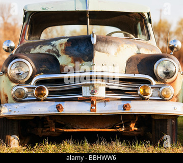 An old abandoned antique car sitting in a field in eastern Stock Photo