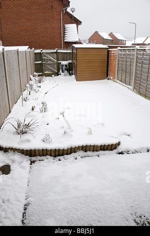 a suburban snowy back garden in dudley during snowfall in spring February 2009 Stock Photo