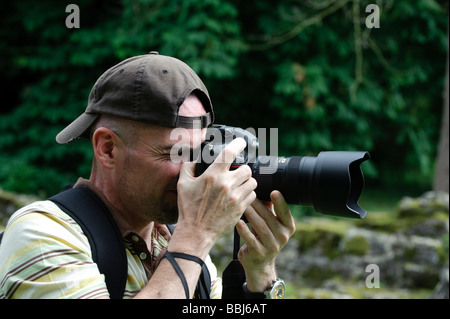 Man using Nikon D3 digital SLR camera to take a photograph Stock Photo