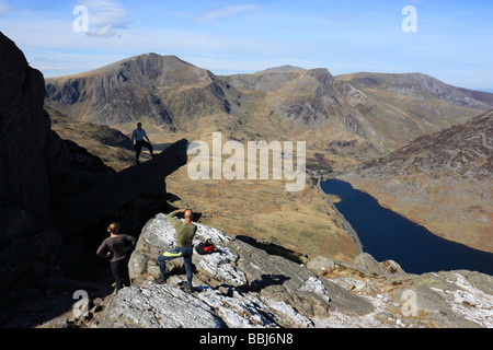 Walkers posing for photographs on 'The Cannon', a rock feature on the mountain of Tryfan, Snowdonia, North Wales Stock Photo