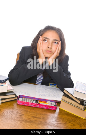 Vertical portrait of a young school girl with her head in her hands looking bored stiff doing her homework Stock Photo