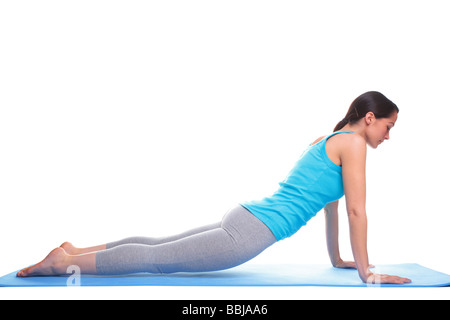 A brunette woman doing stretching exercises on a yoga mat isolated on a white background  Stock Photo