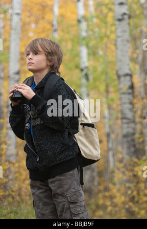 Ten year old boy holding binoculars wearing hemp backpack, Lake Katherine, Riding Mountain National Park, Manitoba Stock Photo