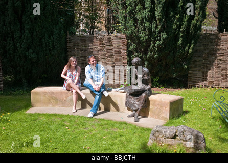 Two young students sitting on a modern bench in the churchyard garden of St Edmund's College Oxford Stock Photo