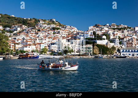 A fishing boat leaves Skopelos harbour The Sporades Greek Islands Greece Stock Photo