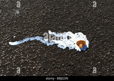 An ice cream cone dropped and melting on the pavement Stock Photo