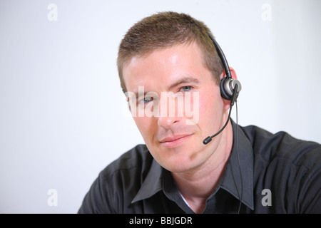 Young man with headset smiling at camera Stock Photo