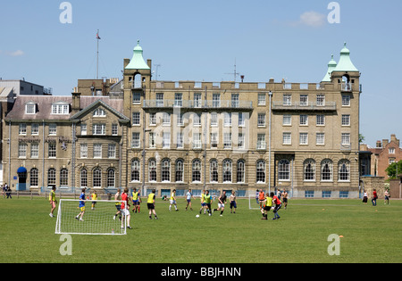 Teenagers playing football in front of the University Arms Hotel on Parkers Piece, Cambridge, UK Stock Photo