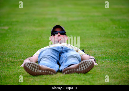 Man laying flat out on a lawn Stock Photo
