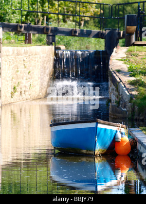 Small rowing boat moored in front of lock gates