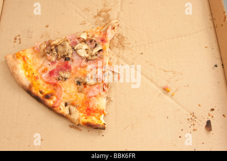 Last slice of ham and mushroom pizza in a cardboard box. Stock Photo