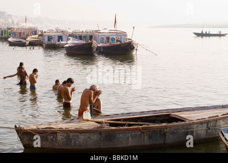 Holy men (brahmins) praying and making offering for river Ganges, holy for the Hindu. Bathing ghats, Varanasi, India. Stock Photo