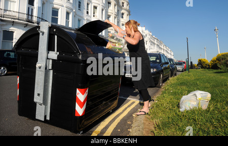 A women uses one of the newly installed communal bins in Brighton's Kemp Town area Stock Photo