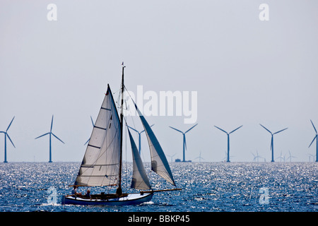 Sailing boat in front of an off shore wind park in the Sound between Denmark and Sweden Stock Photo