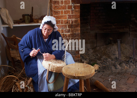 A costumed historical interpreter weaves baskets at the Wythe House Colonial Williamsburg Virginia Stock Photo