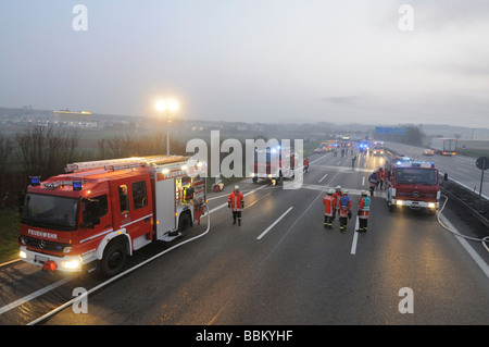 Firefighters during fire-fighting operations involving two trucks after an accident on the motorway A81 between AS Zuffenhausen Stock Photo