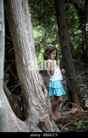 Girl walking through woods holding stick, Ontario Stock Photo