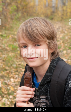 10 years old boy on trail with walking stick, Lake Katherine, Riding Mountain National Park, Manitoba Stock Photo
