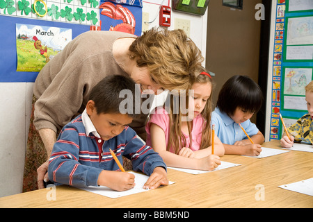 Elementary kids multi ethnic racial diversity racially diverse multicultural mult i cultural interracial students writing in classroom MR Stock Photo