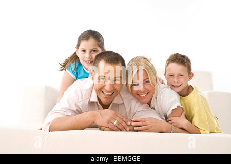 Laughing family lying on a couch Stock Photo