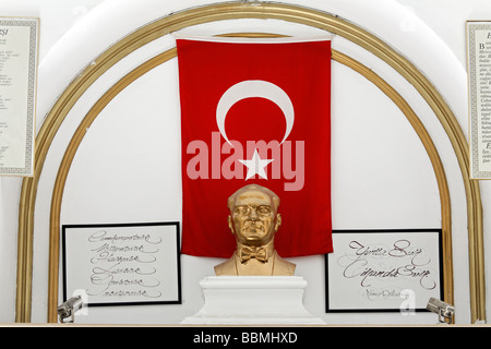 Golden bust of Mustafa Kemal Atatuerk in front of Turkish flags in a house entrance, Beyolu, Istanbul, Turkey Stock Photo
