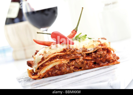Red peppers with lasagna and red wine Stock Photo