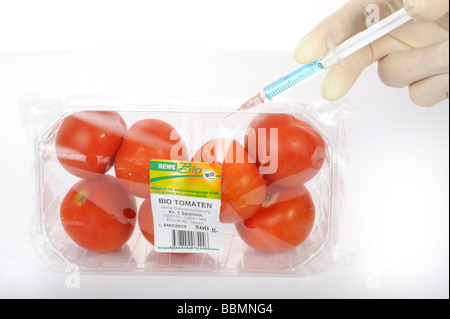 Syringe identification in tomato with BIO on the label, symbolic picture, fraud with food with the BIO label Stock Photo