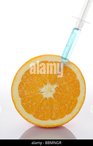Syringe in orange, symbolic picture, genetically modified foods Stock Photo