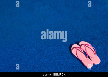 Relaxing summer getaway with pink flip flops and a straw hat beside a ...