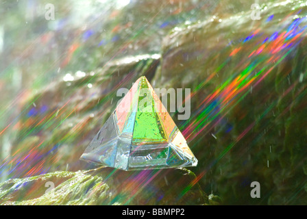 Glass pyramid with coloured rays of light in waterfall Stock Photo