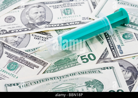 US Dollar bills, Syringe placed on top, close up Stock Photo